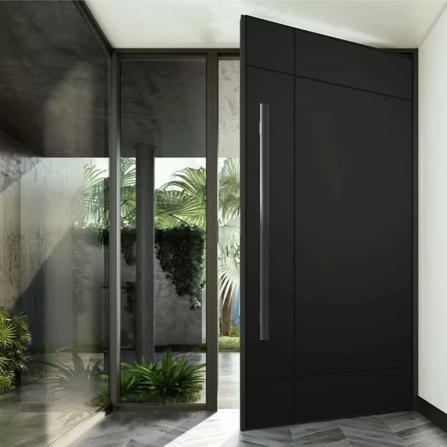Porta pivotante preta em ACM aberta em uma entrada com jardim